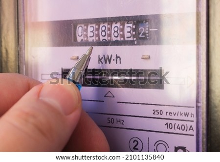 Ballpoint pen showing electricity meter readings. Distribution of electricity in an apartment building, payment of utility services. Royalty-Free Stock Photo #2101135840