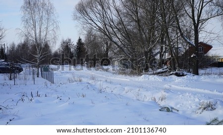 Snowy winter in the Russian village. Snow-covered streets and courtyards, snowy January in the Russian hinterland, Russia.