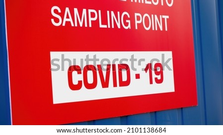 Detail of red label saying COVID-19 sampling point