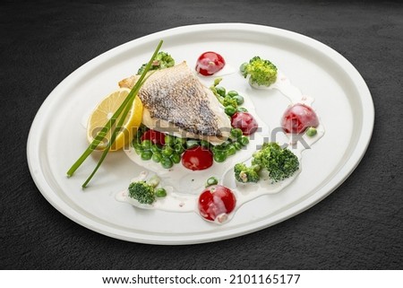 Pike perch on a vegetable pillow . Isolated on a black background.
