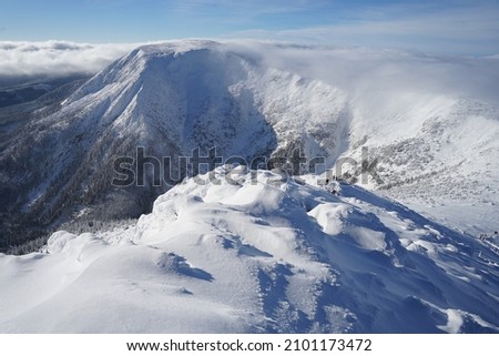 Beautiful Giant Mountains covered with snow on winter sunny day and blue sky, panoramic view from Sniezka Mountain, Poland