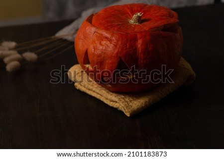 Halloween orange pumpkin on yellow towel on wooden dark table