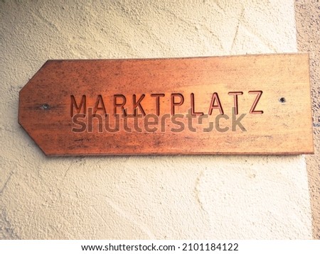 A wooden "Marketplace" sign in German