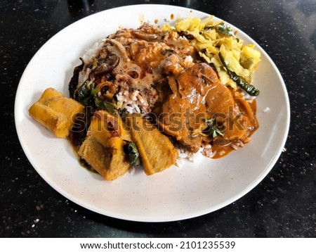 Selective focus with noise effect picture of nasi kandar consist of curry mutton, squid egg and vegetable insight