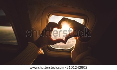 Tourist woman making heart shape with hands in airplane - Travel addicted concept with female enjoying vacation - Travel, holidays and love concept