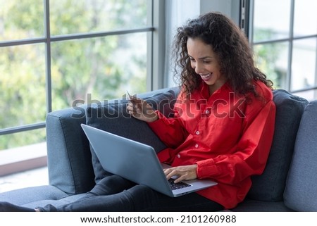 Young woman shopping online on couch at home 