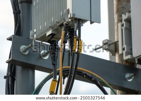 Fifth-generation base stations close-up. A large number of wires coming out of the radio module. Telecommunication pole of 4G and 5G cellular. Macro Base Station. Royalty-Free Stock Photo #2101327546