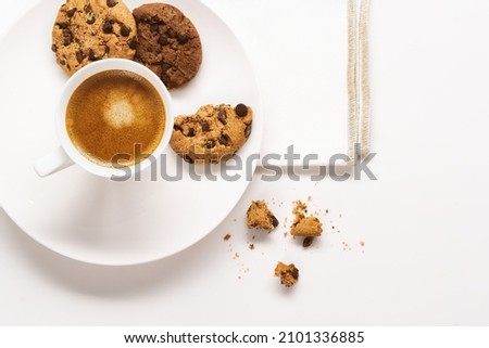  Cup of coffee with milk and chocolate cookie on white background. Top view. Copy space.