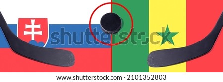 Top view hockey puck with Slovakia vs. Senegal command with the sticks on the flag. Concept hockey competitions