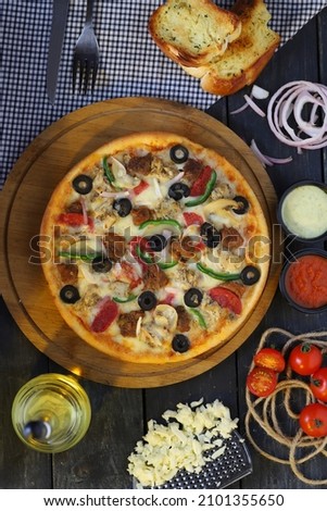 pizza, dish of Italian origin consisting of a flattened disk of bread dough topped with some combination of olive oil, oregano, tomato, olives, mozzarella or other cheese, and many other ingredients, 