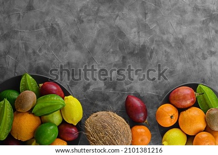 Bite still life on gray cement background. Different drupe fruits and tamarillo. Kiwi on vintage table and other fruits. Copy space for your text. Fruits plate on left side. Royalty-Free Stock Photo #2101381216
