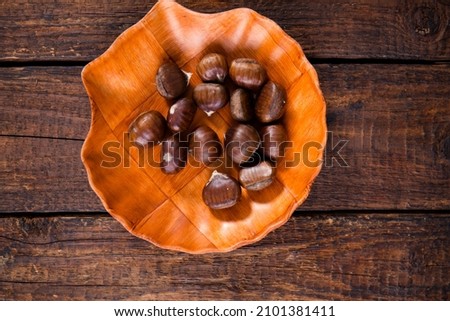 Edible chestnut on brown background, top view