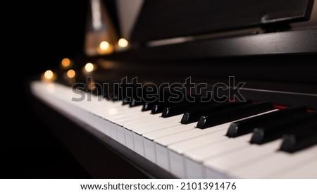 Piano keyboard close up and blurred candle light background. Musical instrument wallpaper 