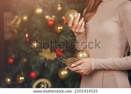 close-up of women's hands with balloons on the background of a Christmas tree
