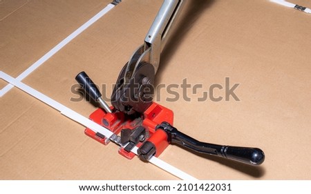 manual strapping of packages for shipping Royalty-Free Stock Photo #2101422031