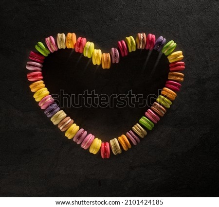 valentine of multicolored macarons on dark background