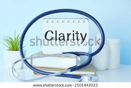 holds a business card with the written word CLARITY, medical concept.