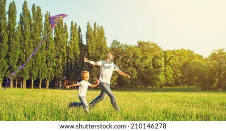 happy family in summer nature. Dad and son child flying a kite Royalty-Free Stock Photo #210146278