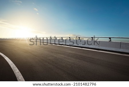 Curvy highway overpass with beautiful sunlight during sunset Royalty-Free Stock Photo #2101482796