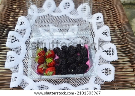 Blueberries and strawberries placed in a container. Can be used for promotional media.