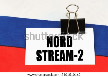 National concept. On the flag of Russia there is a business card with the inscription - Nord Stream 2