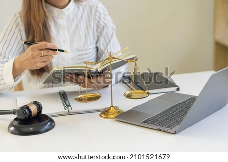 Lawyer businessman working with workplace law books for lawyer ideas consulting with hammers and scales put forward.