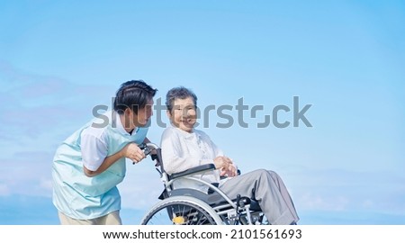 Asian caregiver and a senior woman on the wheelchair, outdoor