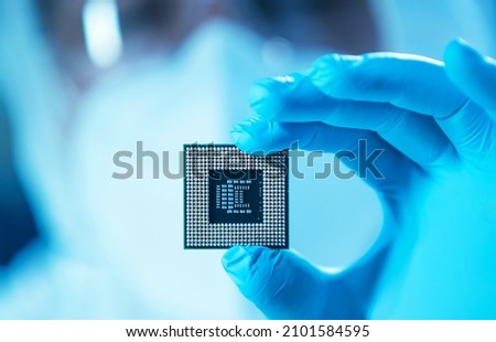 The scientist works in a modern scientific laboratory for the research and development of microelectronics and processors. Microprocessor manufacturing worker uses computer technology and equipment. Royalty-Free Stock Photo #2101584595
