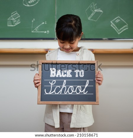 Back to school message against cute pupil showing chalkboard