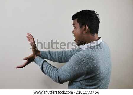 young asian man demonstrating a scene from one of the japanese cartoons shooting plasma energy from both hands