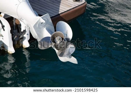 Three-bladed yacht engine propeller with rust spots on it. Shiny metal propeller of yacht engine lifted out of water. Royalty-Free Stock Photo #2101598425