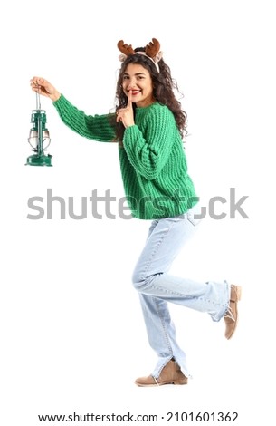 Beautiful walking young woman with lantern showing silence gesture on white background