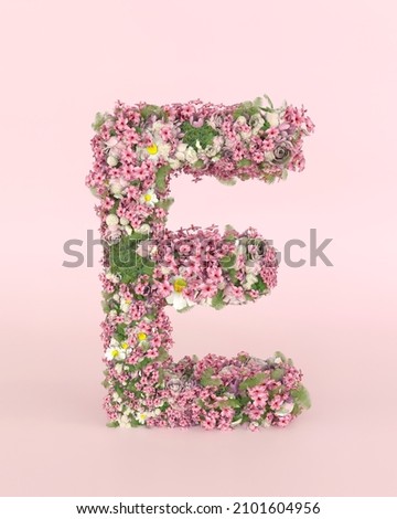 Creative letter E concept made of fresh Spring wedding flowers. Flower font concept on pastel pink background.