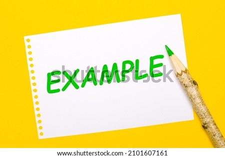 On a bright yellow background, a large wooden pencil and a white sheet of paper with the text EXAMPLE