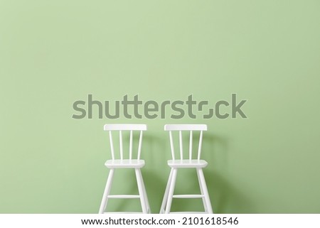 White chairs for children on green background