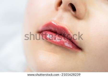 Closeup of female lips after permanent makeup lip blushing procedure Royalty-Free Stock Photo #2101628239