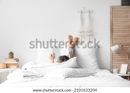 Morning of young woman reading book in bed Royalty-Free Stock Photo #2101633204