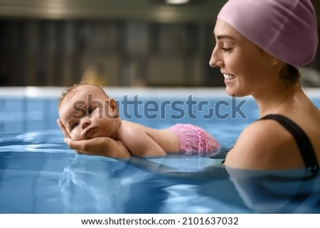 Cute baby with mother in swimming pool Royalty-Free Stock Photo #2101637032