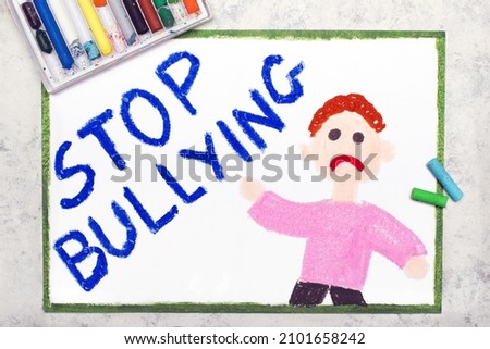 Colorful drawing: A sad boy shows with his hand the inscription STOP BULLYING