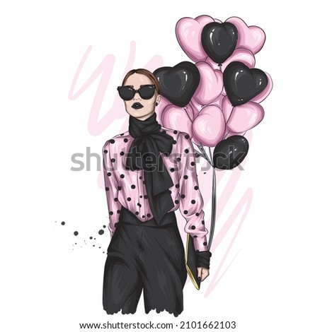 Beautiful girl in stylish clothes and balloons in the form of hearts. Valentine's Day and Love.