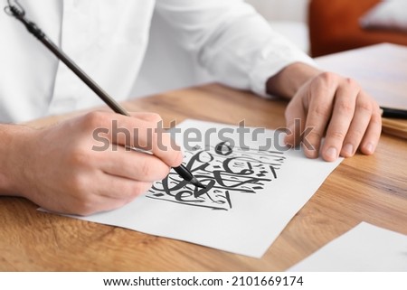 Male Arab calligraphist working in office, closeup Royalty-Free Stock Photo #2101669174
