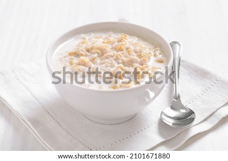 Oatmeal porridge in white bowl, close up view. Royalty-Free Stock Photo #2101671880