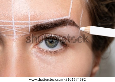 Young woman during professional eyebrow mapping procedure before permanent makeup Royalty-Free Stock Photo #2101674592