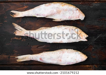Frozen Goatfish raw fish set, on old dark  wooden table background, top view flat lay