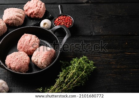 Fresh raw beef meatballs set, on black wooden table background, with copy space for text