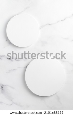Podiums. White round podiums for presentation and cosmetic. Natural beauty pedestal on white marble background. Photography. Top view.