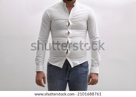 Man wearing tight shirt on white background, closeup. Overweight problem Royalty-Free Stock Photo #2101688761