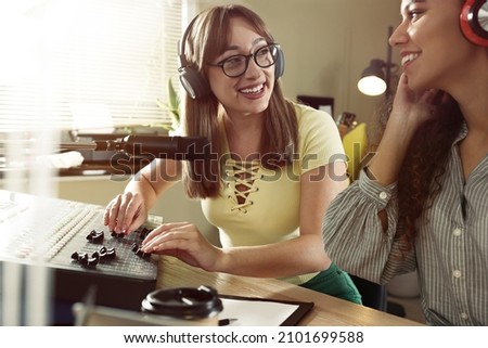 Young women working in modern radio studio with professional equipment