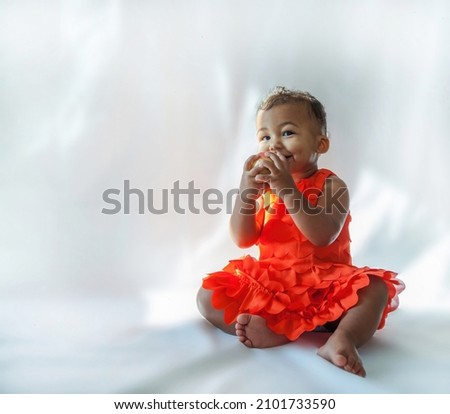 10 month old baby holding an apple in studio