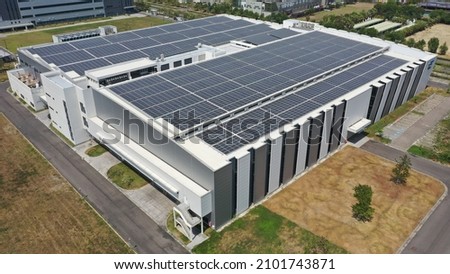 Modern factory building with roof mounted solar system Royalty-Free Stock Photo #2101743871